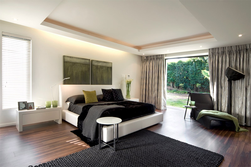 Phòng ngủ màu đen và trắng với một điểm nhấn màu xanh lá cây.